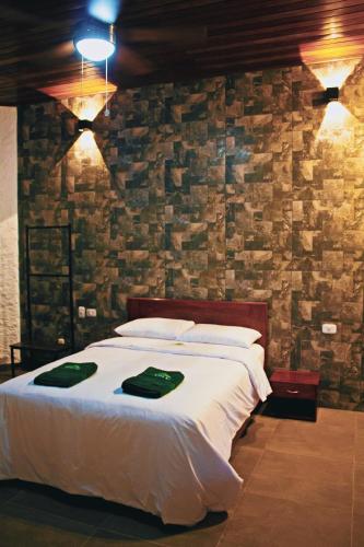 a bedroom with a bed with a stone wall at Apu Samay Nature Lodge in Tarapoto