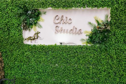 a sign that says chi studio in a green hedge at Chic Studio in Bucharest