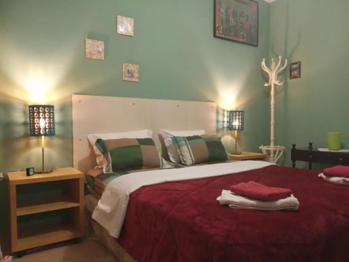 a bedroom with a large bed with red sheets and pillows at Spacious Cosy Apt (up to 5 guests) in Thessaloniki