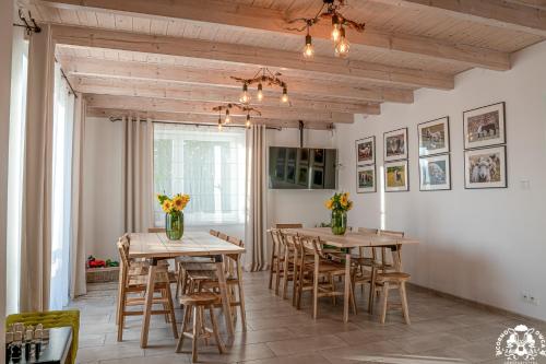 Agroturystyka Corno Owca في Żabnica: غرفة طعام مع طاولات وكراسي خشبية