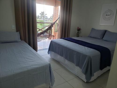 due letti in una stanza con balcone di Apart Resort Vila das Águas Veraneio a Estância