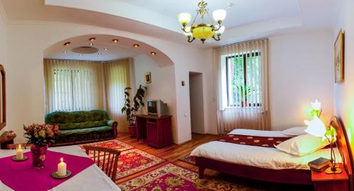 a bedroom with a bed and a living room at Pensiunea Boema in Sinaia