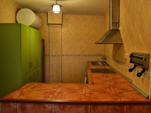 a kitchen with green cabinets and a counter top at El encinar de las Hoces - Vivienda de uso turístico in Castrillo de Sepúlveda