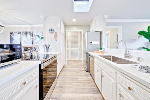 a white kitchen with white cabinets and appliances at Balboa Pier House in Newport Beach