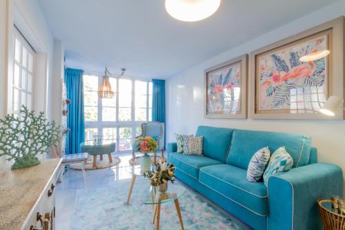 a living room with a blue couch at MARBELLA BANUS SUITES - Iris Tropical Garden Banús Suite Apartment in Marbella