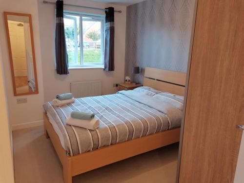 a bedroom with a bed with two towels on it at Cosy Apartment with Balcony in Herne Bay