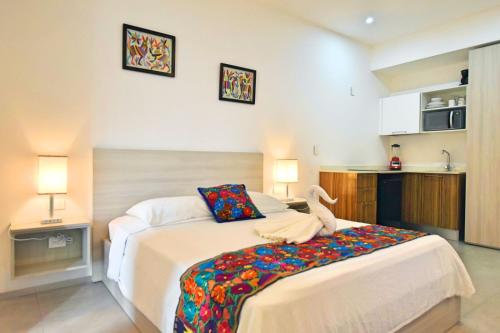 a bedroom with a large bed and a kitchen at Menesse the City by Casago in Playa del Carmen