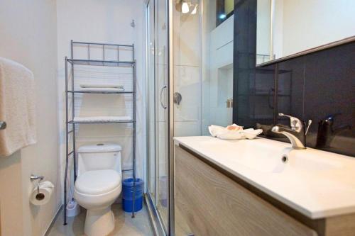 a bathroom with a toilet and a sink and a shower at Menesse the City by Casago in Playa del Carmen