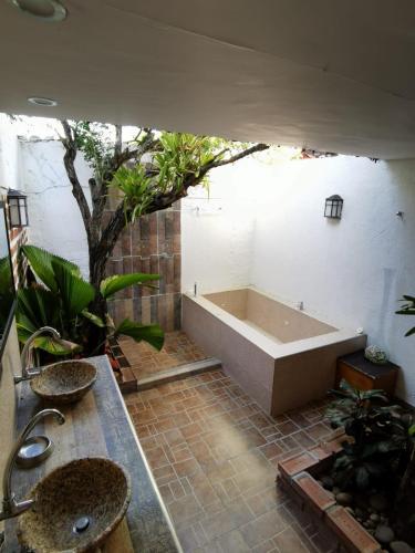a bathroom with a tub and two sinks and plants at Villa del Sol Hotel & Restaurante in Villavieja