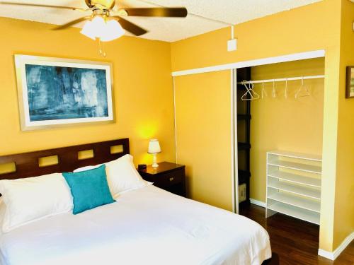 - une chambre avec un lit et un ventilateur de plafond dans l'établissement Palani Condo, à Kailua-Kona