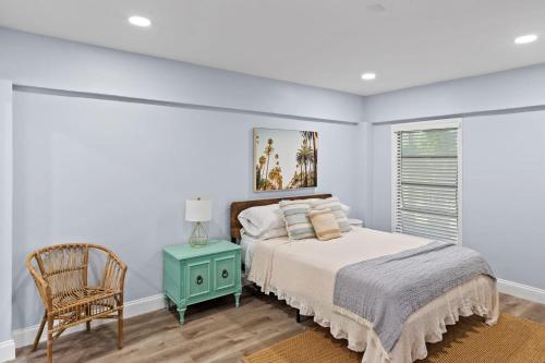 a bedroom with a bed and a chair and a window at Upgraded 2BR Residence with Bikes, Steps to Sanibel Lighthouse in Sanibel