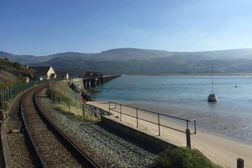 a bridge over a river with a boat in the water at Hendre Fechan Cottage, Nr Barmouth, Pets welcome, beautiful views. in Llanddwywe