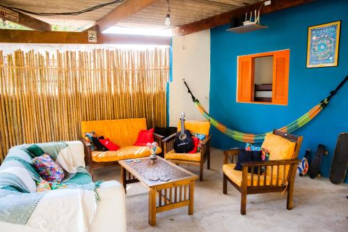 a living room with couches and a hammock at Sintonia Surf Hostel e Bar in Ubatuba