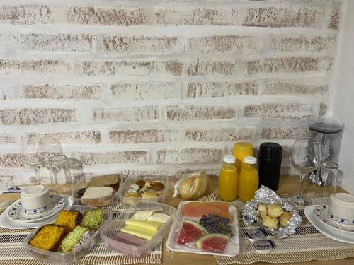 uma mesa com comida e bebidas numa mesa em Villagio da Mantiqueira em Monte Verde