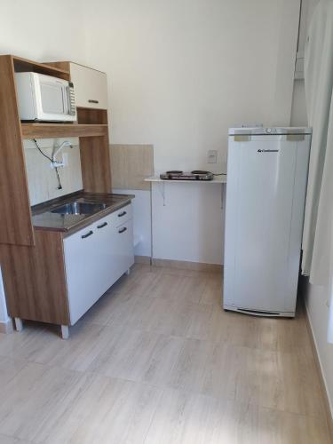a small kitchen with a refrigerator and a sink at Pousada Korb in Santo Amaro da Imperatriz