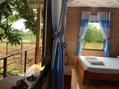 a room with a bed and a balcony with a window at Gibbon Singing Home Stay in Quan Tom