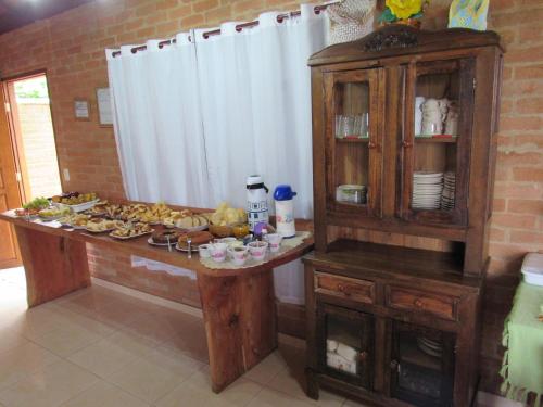 una cocina con una mesa con comida. en CHALÉ NATIVO R Júlio Miranda nº 06 en Conceição da Ibitipoca