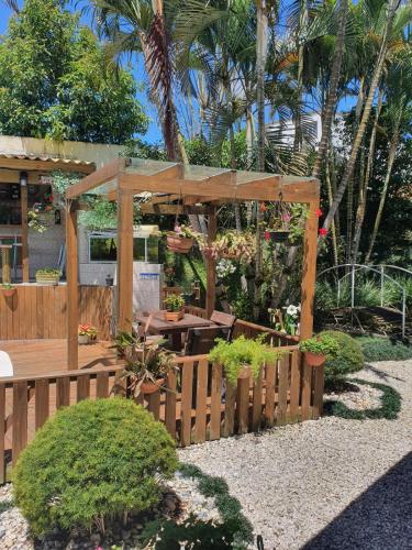 a wooden pergola with a wooden table and a wooden fence at Pousada Korb in Santo Amaro da Imperatriz