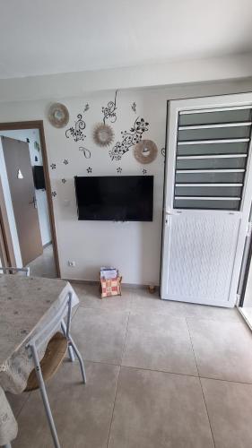 a living room with a tv on a wall at Les hauts du fromager in Le Diamant
