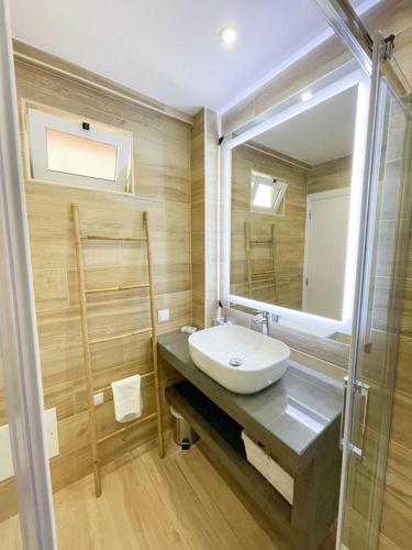 a bathroom with a sink and a mirror at Apartamentos SweetHomes in Faro