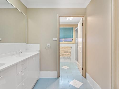 a white bathroom with a sink and a mirror at Ajax Avenue 6 in Nelson Bay