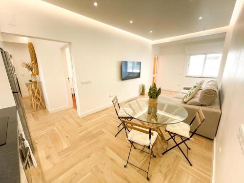 Una sala de estar con una mesa de cristal y sillas. en Apartamentos SweetHomes, en Faro