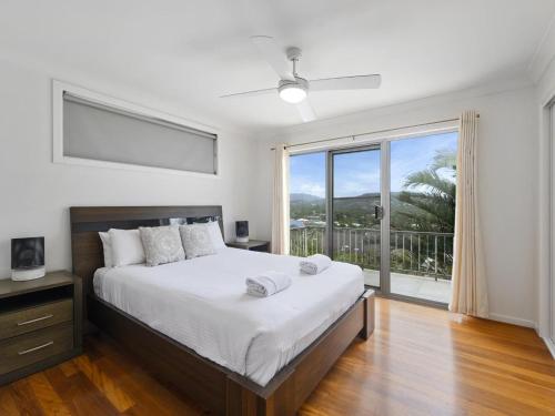 a bedroom with a large bed and a large window at Emerald Views Signal Street 9 in Emerald Beach