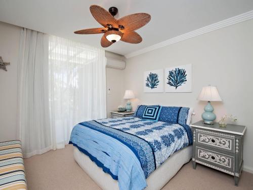 1 dormitorio con 1 cama y ventilador de techo en Aura Apartments Unit 12 59 Shoal Bay Road, en Shoal Bay