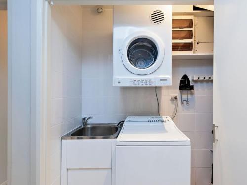 una pequeña cocina con fregadero y lavadora en Aura Apartments Unit 12 59 Shoal Bay Road, en Shoal Bay