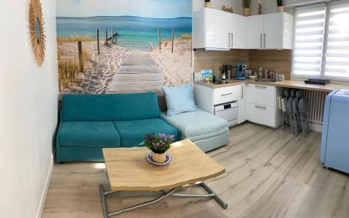 un salon avec un canapé bleu et une table dans l'établissement Le Deauvillais, à Deauville