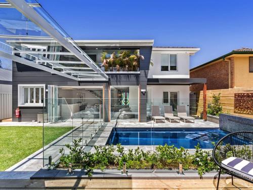 a house with a swimming pool in front of it at La Luna Shoal Bay 30 Horace St Shoal Bay in Shoal Bay