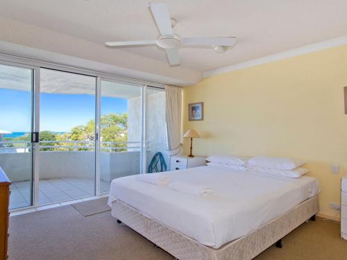 a bedroom with a white bed and a balcony at Cote DAzur 6 Douglas Street 6 in Sunshine Beach