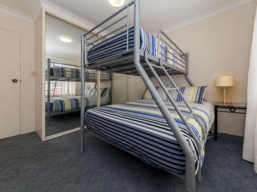 1 Schlafzimmer mit 2 Etagenbetten und einem Spiegel in der Unterkunft Laman Lodge Unit 5 15 Laman Street in Nelson Bay