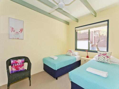 Pokój z 2 łóżkami, krzesłem i oknem w obiekcie Kareela Court 3 Kareela Avenue 14 w mieście Noosa Heads