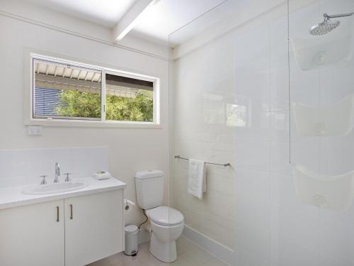 a white bathroom with a toilet and a shower at Kareela Court 3 Kareela Avenue 14 in Noosa Heads