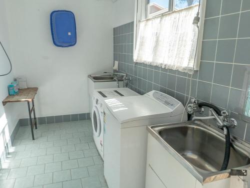 a small bathroom with a washing machine and a sink at Sand and Sea 7 in Sawtell
