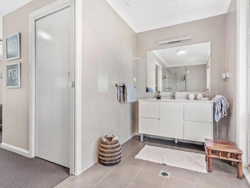a bathroom with a sink and a mirror at Private coastal getaway Corlette in Corlette