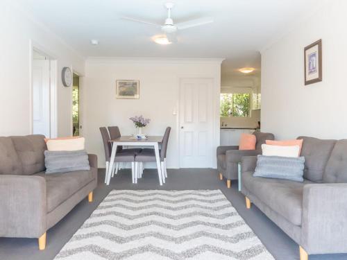 a living room with two couches and a table at Tamara Court in Sawtell