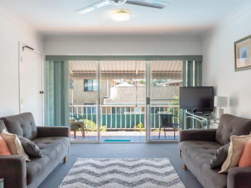 a living room with two couches and a tv at Tamara Court in Sawtell