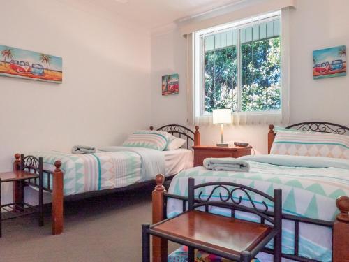 a bedroom with two beds and a window at Tamara Court in Sawtell