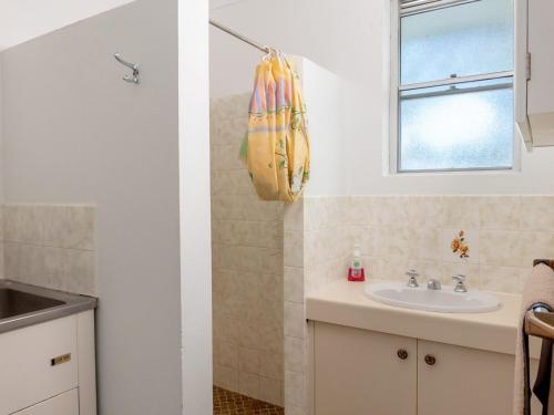 a bathroom with a sink and a window and a mirror at Tamara Court in Sawtell