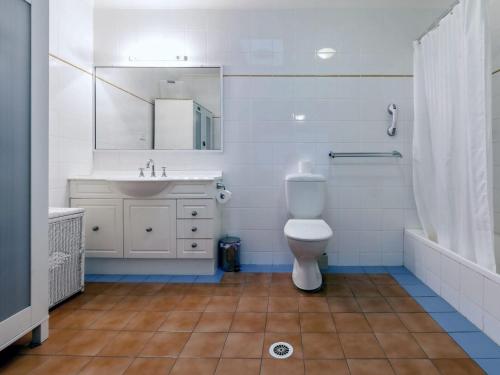 a bathroom with a toilet and a sink and a mirror at Horizons Golf Club Villa 124 in Salamander Bay