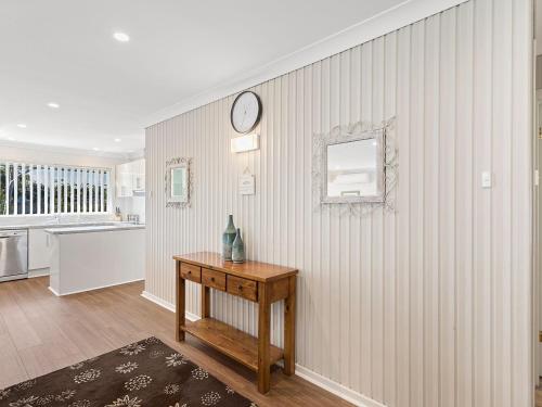 a room with a table and a clock on a wall at Bay Serene 15 Mistral Close in Nelson Bay