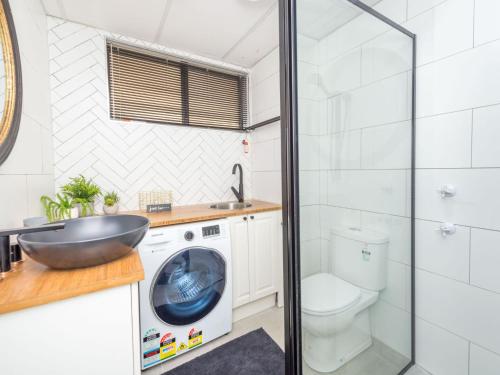 a bathroom with a washing machine and a sink at Bay Village Unit 2 47 Shoal Bay Road in Shoal Bay