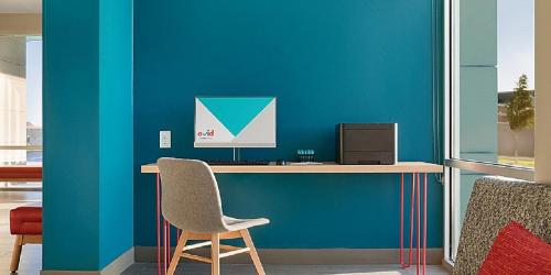 a desk with a chair and a computer on it at avid hotels - Zeeland by IHG in Holland