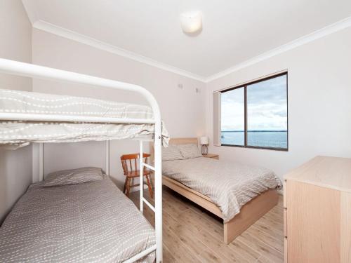 a bedroom with two bunk beds and a window at Bay Village Unit 6 47 Shoal Bay Road in Shoal Bay