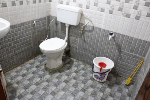 a bathroom with a toilet and a sink at Mountainmist Holidays in Ramakkalmedu