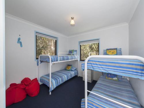 a room with three bunk beds and two windows at Carindale Unit 21 19 Dowling Street in Nelson Bay