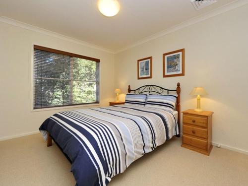 a bedroom with a bed and a window at Marine Dr 2 70 Fingal Bay in Fingal Bay