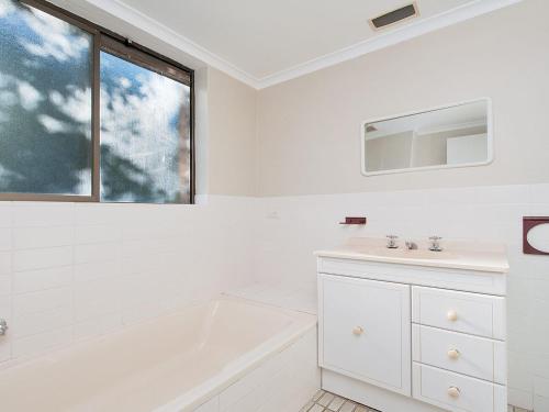 a white bathroom with a tub and a sink at Misthaven Unit 1 12 Mistral Close in Nelson Bay